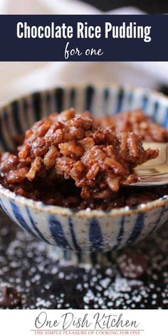 chocolate rice pudding in a blue and white bowl with a spoon sticking out of it