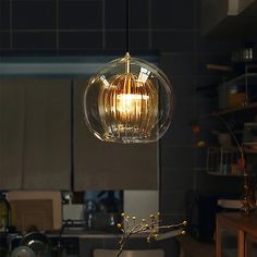 a kitchen filled with lots of counter top space and a light hanging from the ceiling