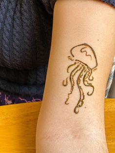 a person with a tattoo on their arm that has a jellyfish drawn on it