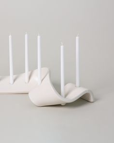 four white candles sitting on top of each other