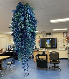 a classroom with blue and green decorations hanging from the ceiling