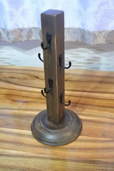 a pair of coat stands on top of a wooden table next to a curtain rod