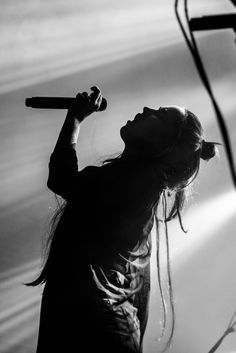 a woman holding a microphone up to her mouth