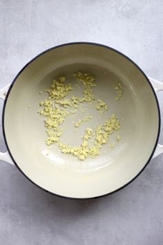 a pan filled with food sitting on top of a white counter next to a knife