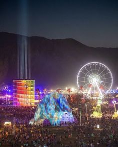 a large group of people standing around a carnival at night