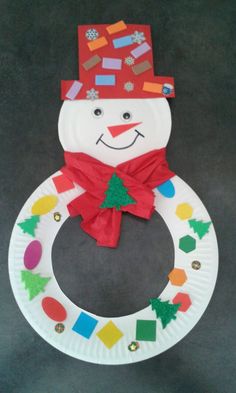 a paper plate snowman with a red hat and scarf