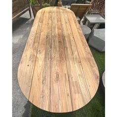 a large wooden table sitting on top of a grass covered field next to potted plants