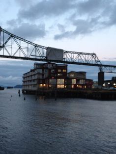 a large bridge spanning over the water with buildings on it's sides at night