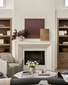 a living room filled with furniture and a fire place in front of a book shelf