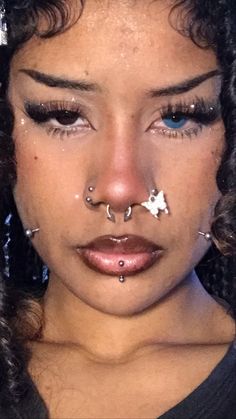 a close up of a person with piercings on her nose and nose ring in front of their face