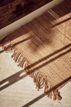 a tan rug with fringes on the floor