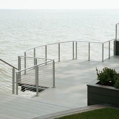 there is a bench on the side of this pier next to the water and plants