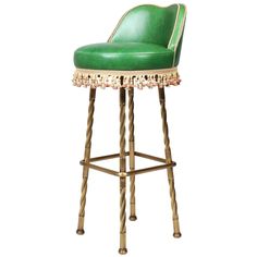 a green bar stool with gold trimmings and beading on the backrest