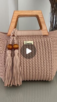 a handbag with a wooden handle and tassels