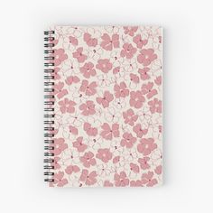 a spiral notebook with pink and white flowers on the front, in an abstract pattern