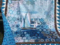 a quilt with sailboats in the water on it