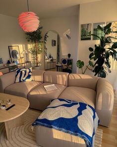 a living room filled with furniture and a large plant in the middle of the room