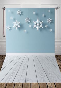 an empty room with snowflakes on the wall and wood flooring in front of it