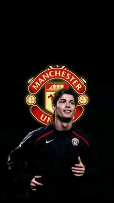 a man standing in front of a black background with the manchester united logo on it