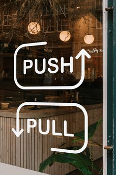 the words push and pull are written in white on a glass window with green trim