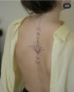 the back of a woman's neck with an intricate flower tattoo on her left side