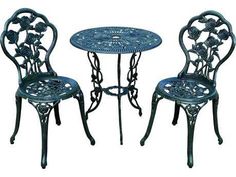 two wrought iron chairs and a table with flowers on the top, set against a white background