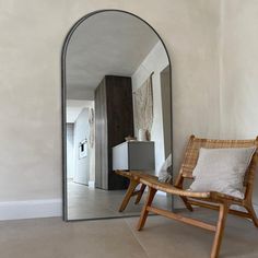 a chair sitting in front of a large mirror