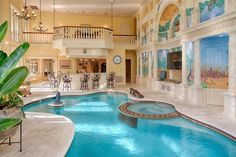 a large indoor swimming pool in the middle of a living room and dining room area