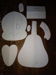 paper cut out of the shape of a bear and other items on a wooden table