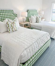 two beds in a room with green and white checkerboard covers on the bed