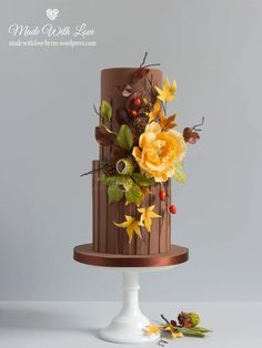 a three tiered cake decorated with flowers and leaves