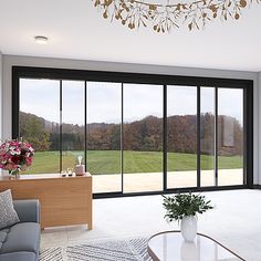 a living room filled with furniture and large windows