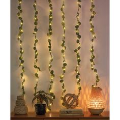 some lights that are hanging from the side of a wall next to a vase and lamp