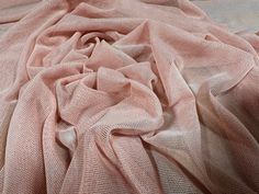 a bed covered in pink sheets and pillows