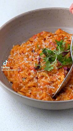 a bowl filled with pasta and garnished with parsley