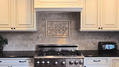 a stove top oven sitting inside of a kitchen next to white cabinets and counter tops