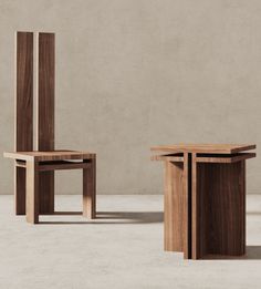 two wooden chairs sitting next to each other on top of a cement floor in front of a wall