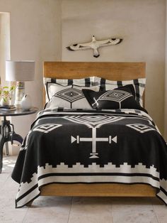 a black and white comforter set with crosses on it in the middle of a room