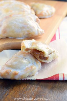 three pastries sitting on top of a wooden cutting board