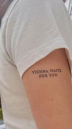 a woman with a tattoo on her arm that says, vienna waits for you in black ink