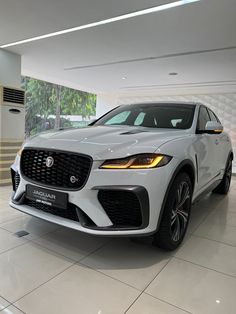 a white car is parked in a showroom