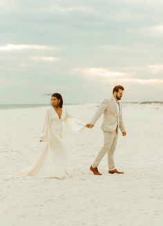 a man and woman are walking on the beach