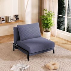 a blue chair sitting on top of a rug next to a window