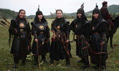 a group of people standing next to each other on top of a lush green field