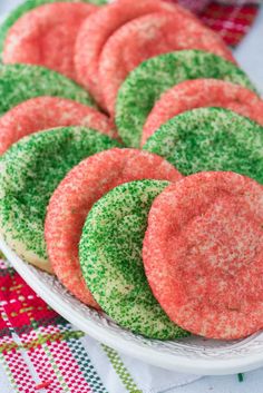 a plate full of green and red sprinkle cookies on top of a table