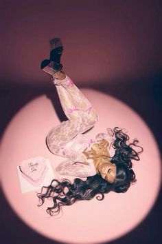 a woman's hair laying on top of a table next to an empty bottle