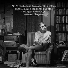 a man sitting in a chair next to a bookshelf with a quote on it