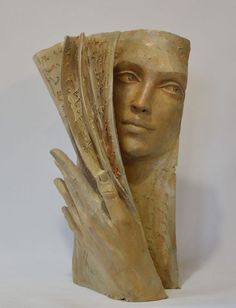 a sculpture of a woman's head with her hands on it