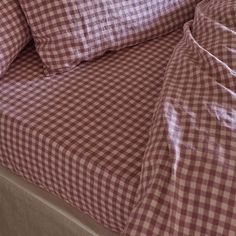 a close up of a checkered bed sheet and pillowcase with two pillows on it