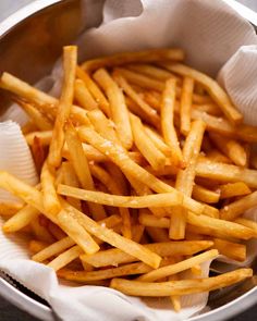 french fries in a silver bowl on a table